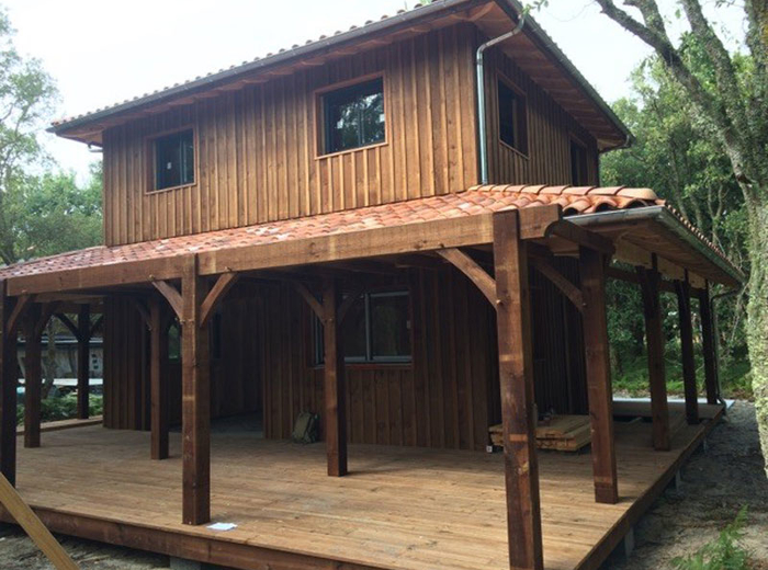 Maison en bois à bardage vertical et pergola